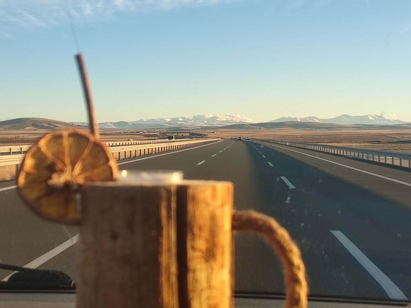 Kaffeebecher auf der Straße mit Bergblick